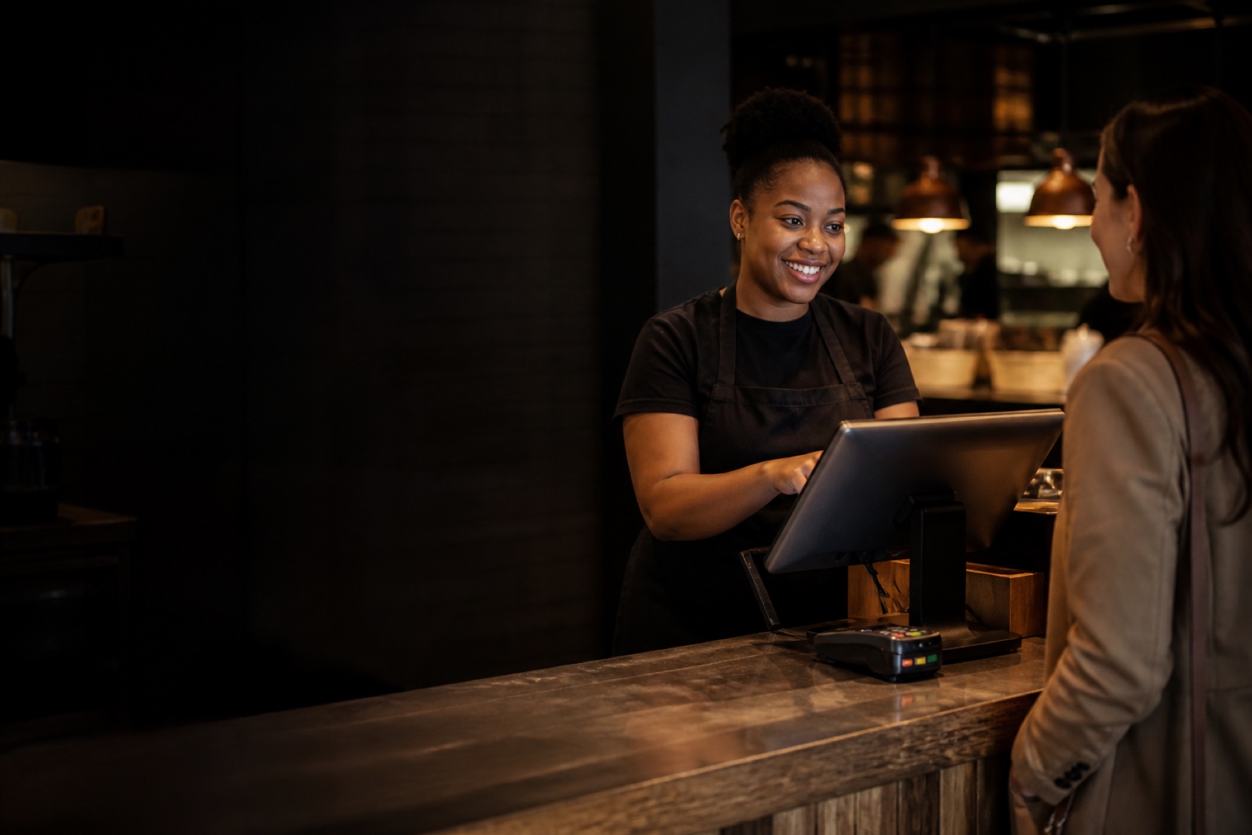 A counter operator completing a customer order on a point-of-sale workstation.